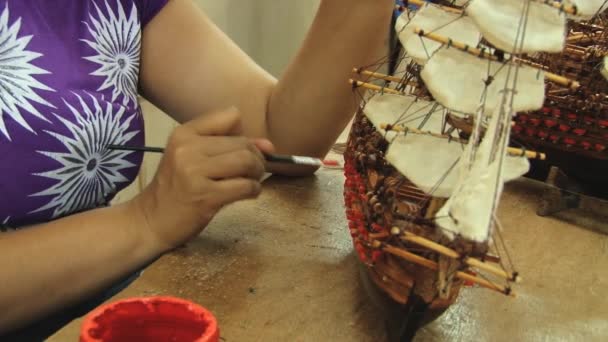 女性はモーリシャスのキュレピペでのワークショップで木製の船のモデルをペイント. — ストック動画