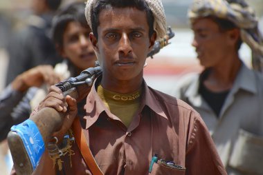 Young Yemeni man holds a rifle in Aden, Yemen. clipart