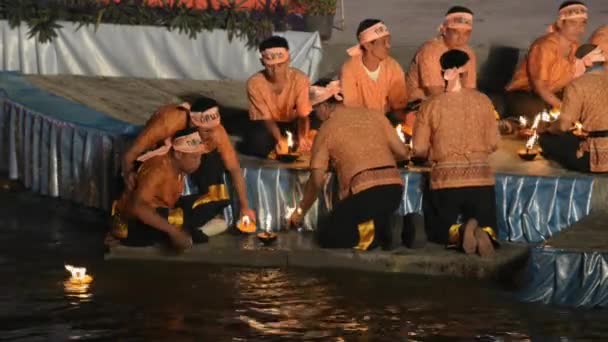Menschen stellen brennende Kokosnussschalen-Kerzen auf Wasser während der loi krathong Feier in tak, Thailand. — Stockvideo