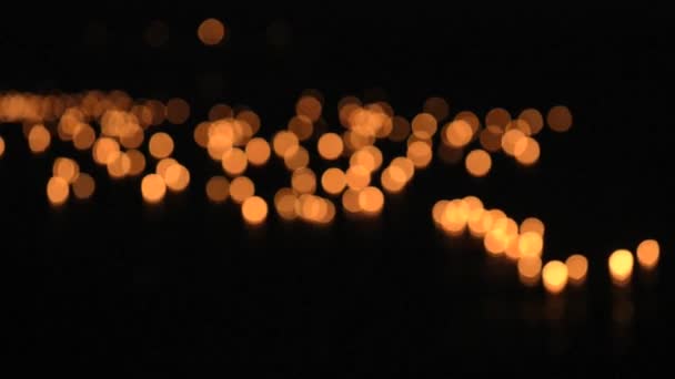Burning candles float on water during Loi Khrathong celebration in Sukhothai, Thailand. Deep out of focus. — Stock Video