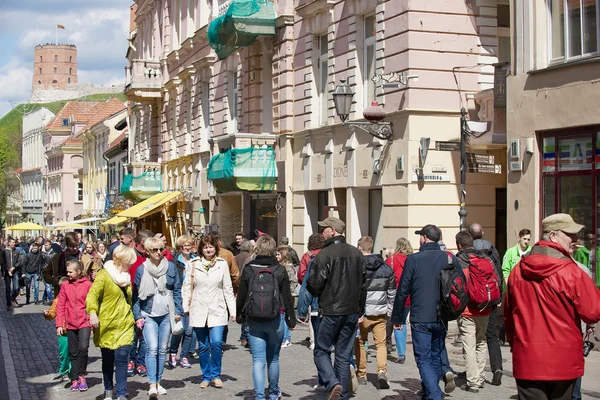 Menschen gehen durch die Straße der Altstadt mit dem Gediminas-Turm im Hintergrund in Vilnius, Litauen. — Stockfoto