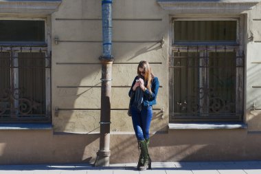 Genç Bayan kaldırım Vilnius, Litvanya akıllı telefon ekranına bakar.