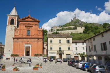 People walk by the central square of the medieval town of Pennabilly, Italy.
