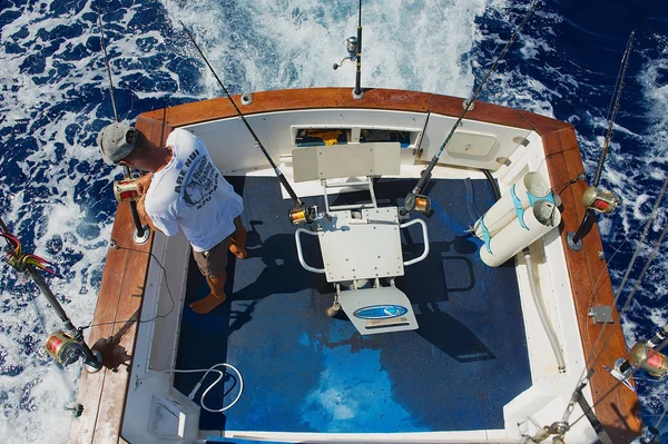 Marinheiro fica pronto carretéis e hastes para a pesca do jogo, Reunião . — Fotografia de Stock