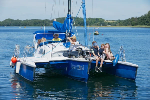 La gente disfruta de un viaje en barco en el lago Galve en un caluroso día de verano en Trakai, Lituania . — Foto de Stock