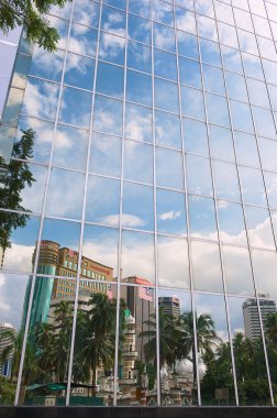 Reflection of the mosque and office buildings in the modern building windows in Kuala Lumpur, Malaysia.