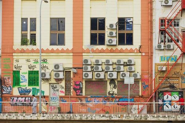 People walk by a backstreet in Kuala Lumpur, Malaysia. — Stockfoto