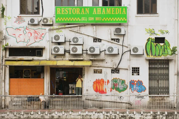 Man stands at the restaurant entrance at the backstreet in Kuala Lumpur, Malaysia. — Stockfoto