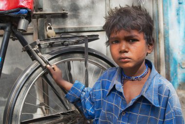 Portrait of unidentified boy with a bicycle at the street of Jodhpur, India.