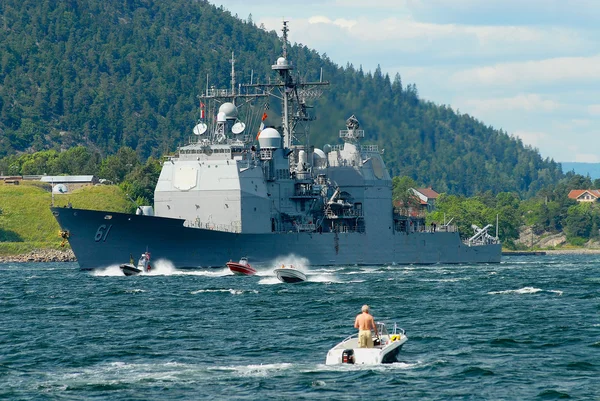 People in motorboats follow norwegian military ship in a fjord in Frogn, Norway. — Stockfoto