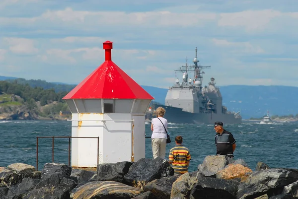 People watch military ship passing by the fjord in Frogn, Norway. — Stockfoto