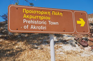Exterior of the sign pointing to the Akrotiri archaeological site in Akrotiri, Greece. clipart