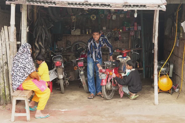 Emberek motorkerékpár javítás egy műhelyben Puthia, Banglades. — Stock Fotó