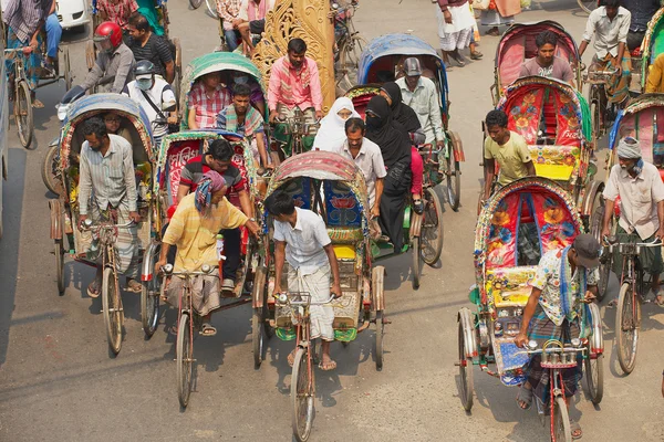 Рикши перевозят пассажиров в Дакке, Бангладеш . Стоковое Фото
