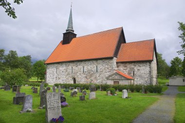 Exterior of the medieval Stiklestadt church and cemetery in Stiklestadt, Norway. clipart