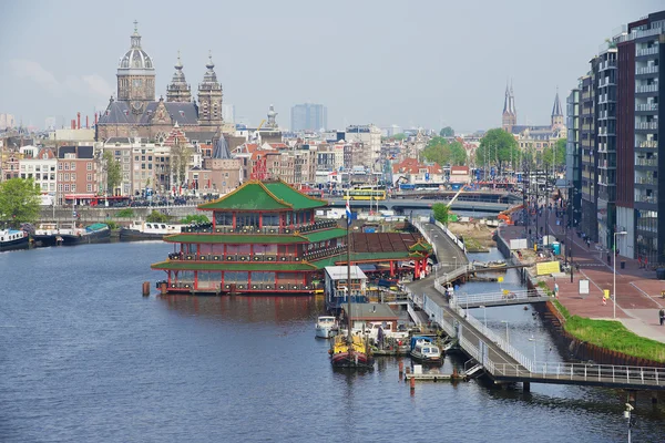 Pohled do města Amsterdamu s kanálem, historických budov a Bazilika svatého Mikuláše v Amsterdamu, Nizozemsko. — Stock fotografie