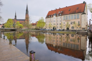 Uppsala, İsveç'te suda yansıtan tarihi binalar için görüntüleyin.