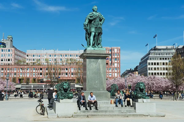 Az emberek élvezik ebédidőben ül alatt Karl Xii szobrot Kungstradgarden, Stockholm, Svédország. — Stock Fotó