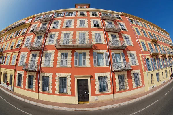 Exterior da bela casa de estuque vermelho com janelas tradicionais de persianas francesas e varandas em Nice, França . — Fotografia de Stock