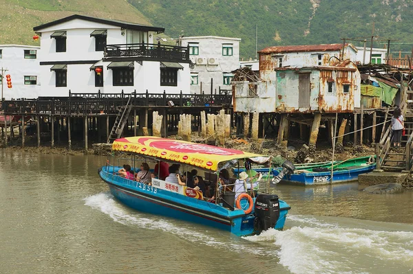 Tourists enjoy boat trip at the Tai O fishermen village with stilt houses in Hong Kong, China. Tai O is a famous tourist destination in Hong Kong. — Stock Photo, Image