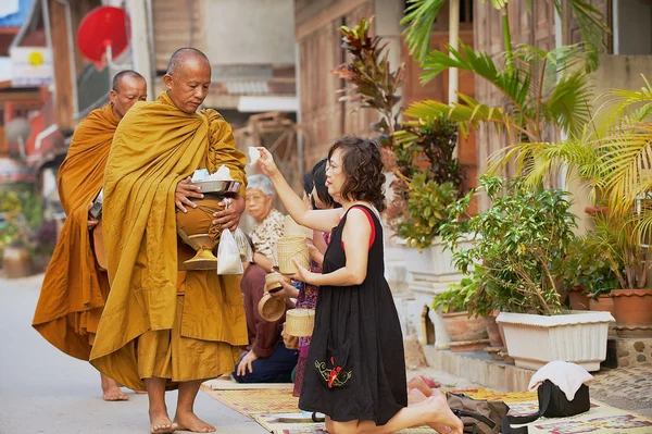 Mensen bieden kleefrijst boeddhistische monniken in de ochtend in Chiang Khan, Thailand. — Stockfoto