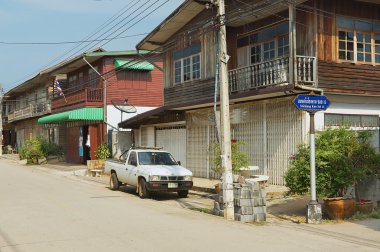View to the street with traditional residential buildings in Chiang Khan, Thailand.
