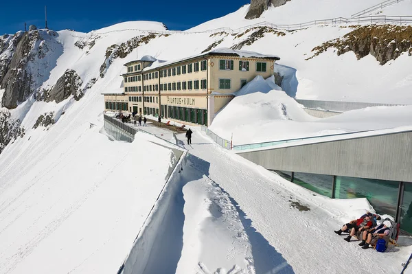 Menschen sonnen sich auf der Terrasse des Luxushotels pilatus-kulm auf dem Gipfel des Pilatus-Berges in Luzern, Schweiz. — Stockfoto