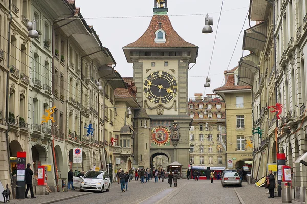 People walk by the street with the historic Bern Clock tower at the background in Bern, Switzerland. ロイヤリティフリーのストック画像