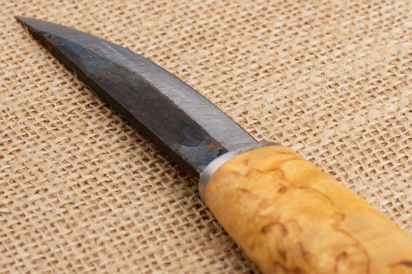 Традиционный грубый финский нож ручной работы с деревянной березовой ручкой на старом мешковом фоне . — стоковое фото