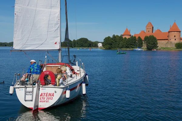 Emberek élvezik hajókirándulás Galve tó a Trakai vár, a háttérben egy forró nyári napon, Trakai, Litvánia. — Stock Fotó