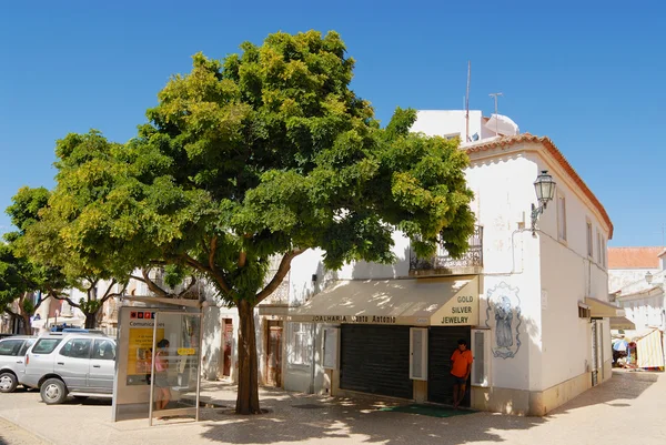 Menschen verstecken sich im Schatten an einem heißen Tag auf der Straße in Lagos, Portugal. — Stockfoto