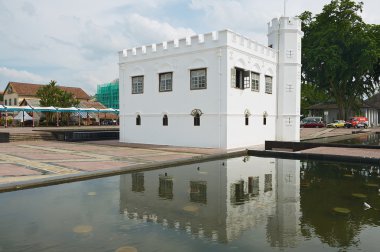 Beyaz tarihi binanın dış Kuching, Malezya havuzda su yansıması.