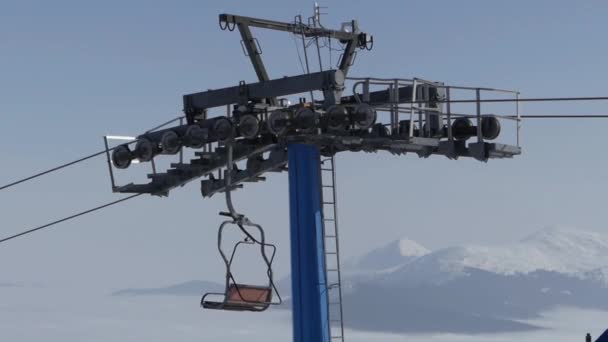 Elevador de sillas vacío en la cima de la montaña. Hermosa vista en el fondo . — Vídeo de stock