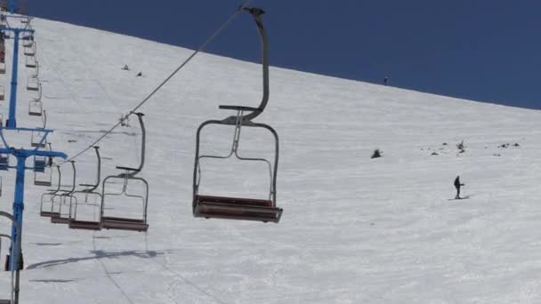 Empty seats of the chair lift go down from the top of mountain. — Stock Video