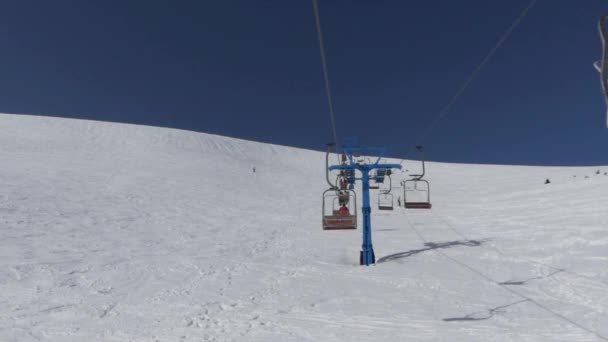 Lege stoelen van de stoeltjeslift naar beneden vanaf de top van de berg. — Stockvideo