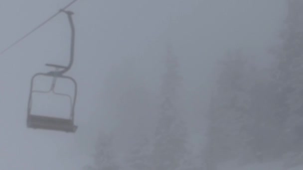 Сидения кресельного лифта в тумане. Горнолыжный курорт в горах . — стоковое видео