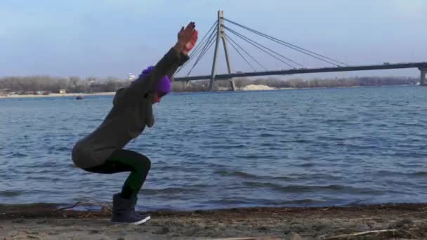 Kız Yoga poz ayakta. Arka planda köprü ve nehir. — Stok video