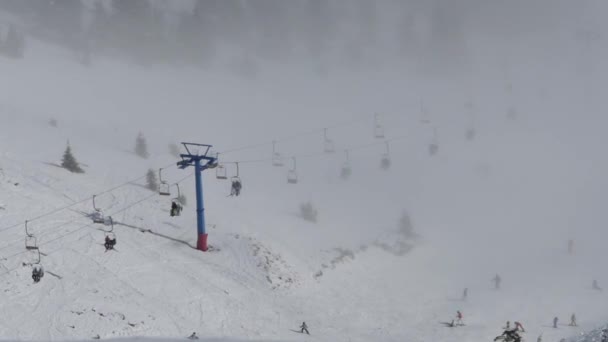 Ski lift lyfter människor till toppen av berget från molnen. Ovanifrån. — Stockvideo