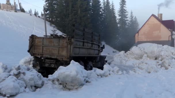 Camión conduciendo en un camino de montaña en el bosque en la nieve . — Vídeo de stock