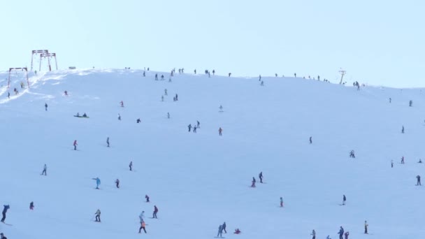 La gente está esquiando y haciendo snowboard en las montañas . — Vídeos de Stock