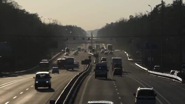 Κυκλοφορία των αυτοκινήτων σε αυτοκινητόδρομο στο ηλιοβασίλεμα. — Αρχείο Βίντεο