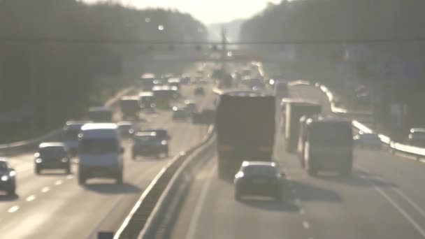 Biltrafik på motorvejen ved solnedgang ud af fokus . – Stock-video