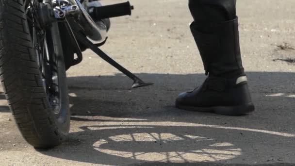 Πόδι ενός ανθρώπου που προσπαθεί να ξεκινήσει μια μαύρη μοτοσικλέτα. — Αρχείο Βίντεο