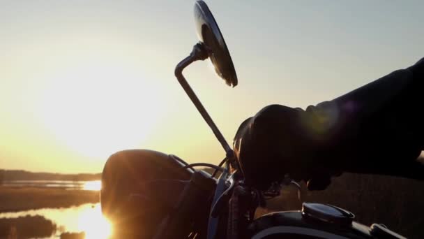 La main ajustant le rétroviseur de la moto au coucher du soleil . — Video