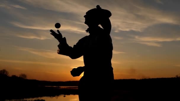 Stilt Walker hace malabares en cámara lenta al atardecer . — Vídeos de Stock