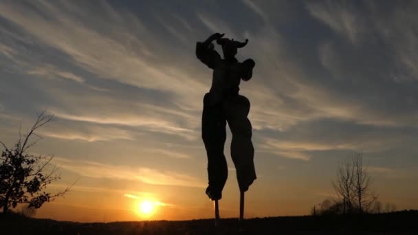 Stilt Walker a dançar ao pôr-do-sol. Espantoso espectáculo. Ação em câmera lenta . — Vídeo de Stock