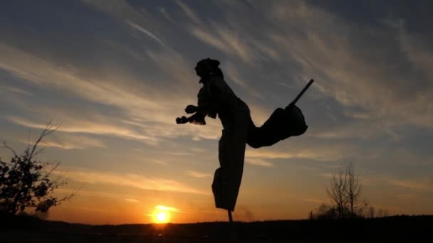 Stelzenläufer springen auf einem Bein und jonglieren. Zeitlupe bei Sonnenuntergang. — Stockvideo