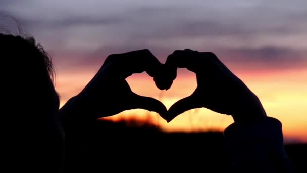 Kéz a szív betesz a naplementét. Lassú mozgás. — Stock videók