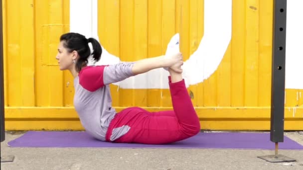 Mädchen im Kostüm macht Bogenpose aus dem Yoga. — Stockvideo