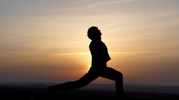 Mann praktiziert Yoga bei Sonnenaufgang. — Stockvideo